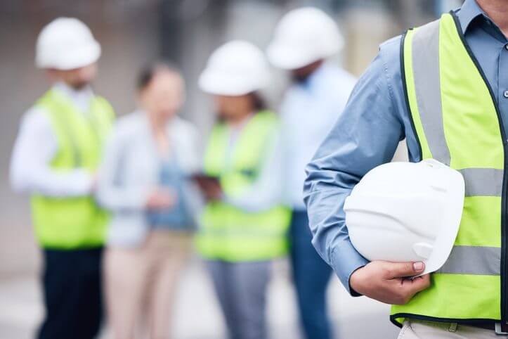 Construction worker in high-visibility gear reviewing safety checklist
