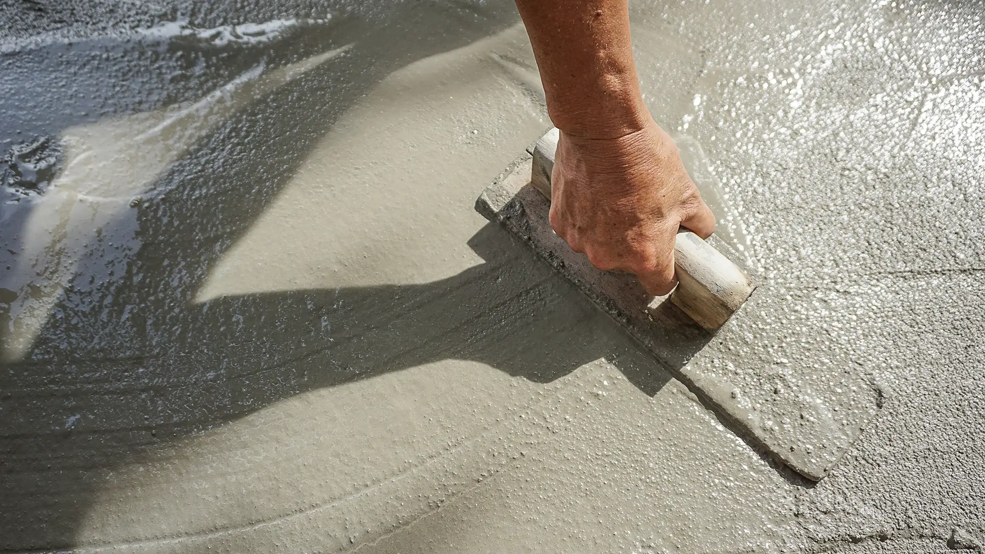 Workers finishing a newly poured concrete sidewalk