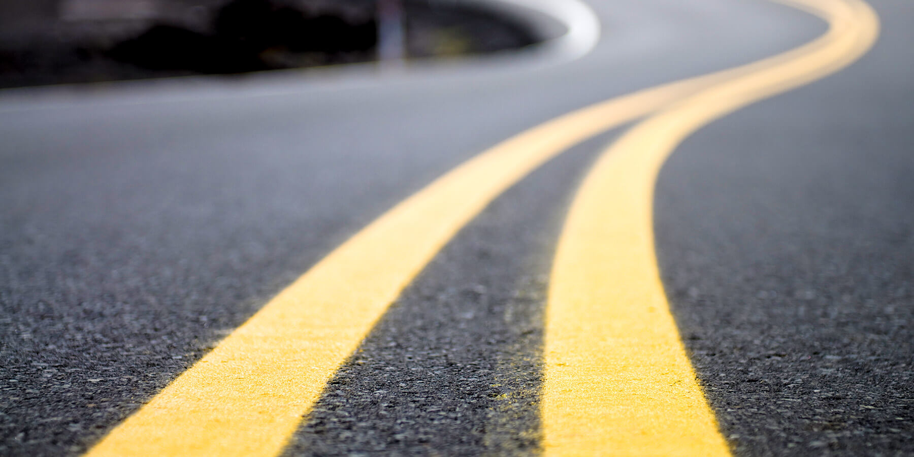 Close-up of a new, perfectly smooth asphalt road being paved.